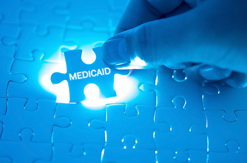 The word medicaid written on a puzzle piece being placed in the larger puzzle